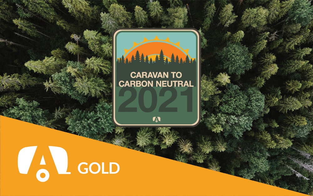 Gold tag with the Caravan to Carbon Neutral sticker on a tree background